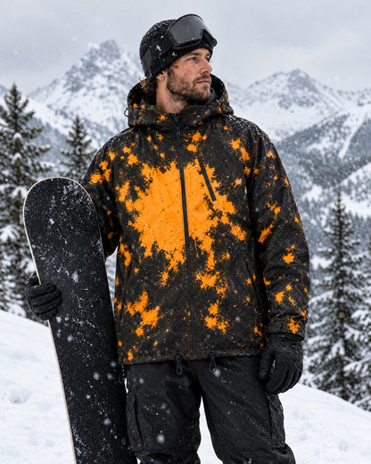 Snowboarder wearing the Flashpoint color changing jacket in Blaze on a mountain, orange splashes on black