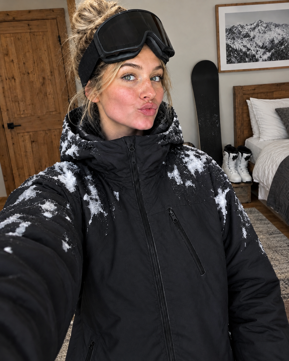 Woman takes a ski lodge selfie in the Flashpoint color changing jacket, white showing where snow melted on her shoulders