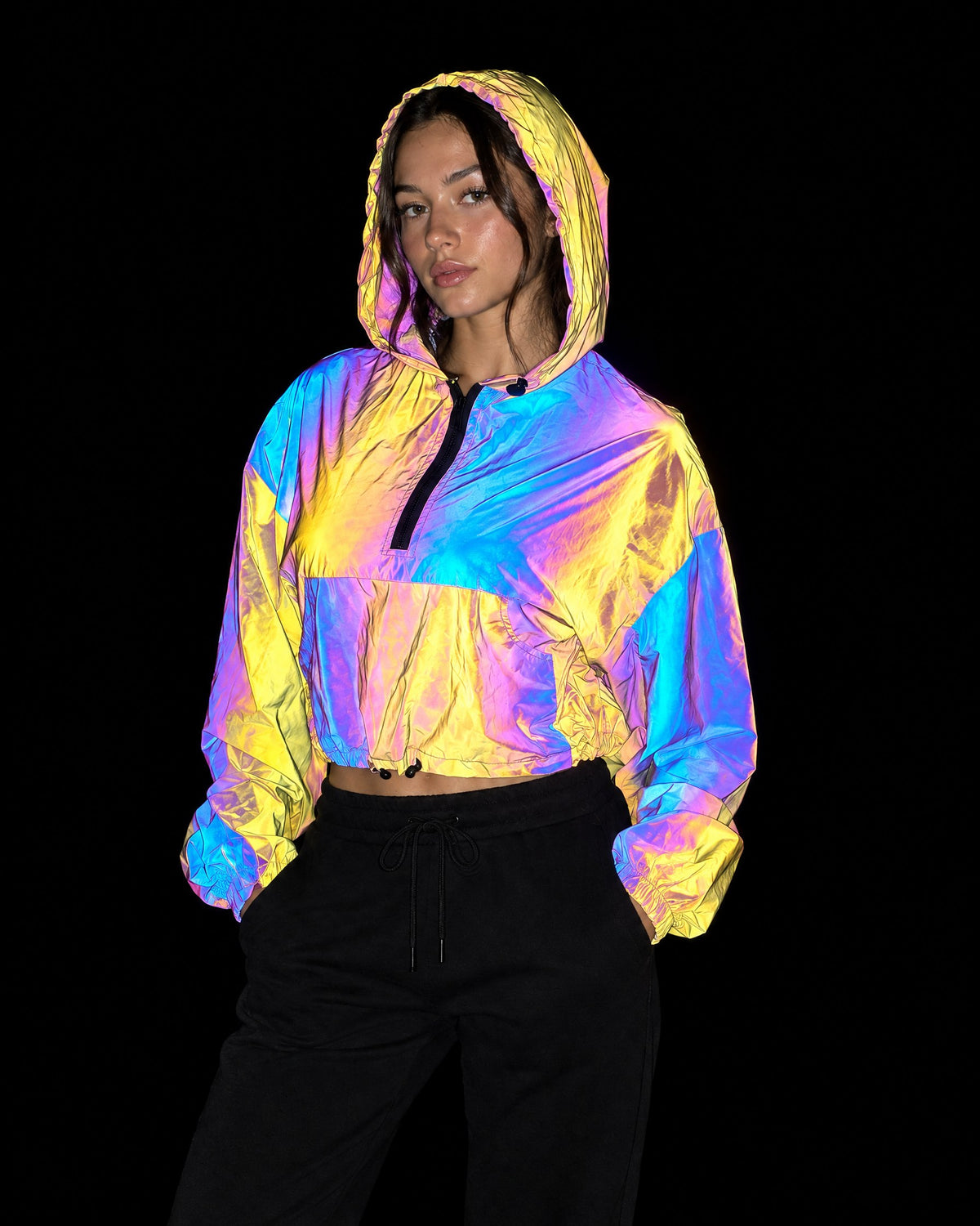 Prism reflective cropped hooded jacket lighting up gold, pink and blue under camera flash at night