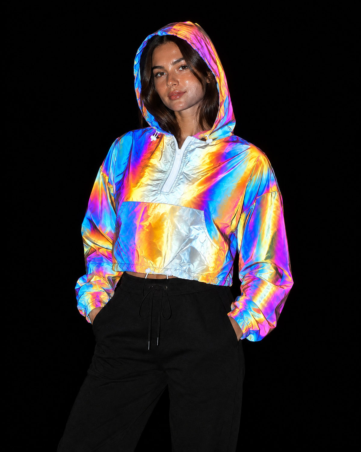 Rose reflective cropped hooded jacket lighting up in rainbow colours under camera flash at night