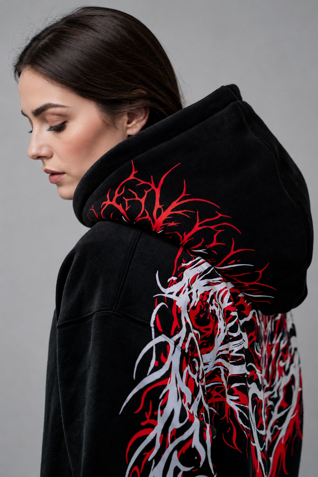Close view of the Reflective Hoodie v2 hood and shoulder on a model, showing the red and white branching print running over the hood and across the upper back.