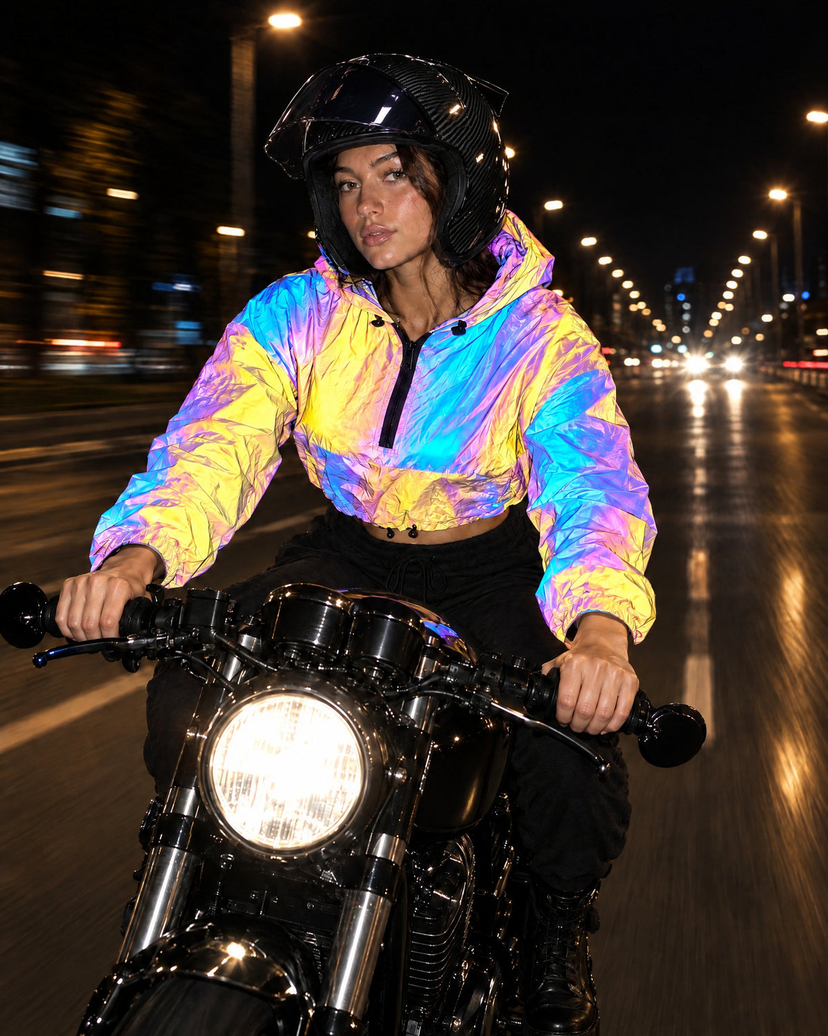 Rider in a Prism reflective cropped jacket and carbon-look helmet on a motorcycle at night